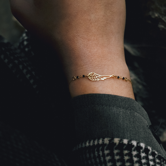 AV χρυσό γυναικείο βραχιόλι με σχέδιο φτερό και μαύρες πέτρες